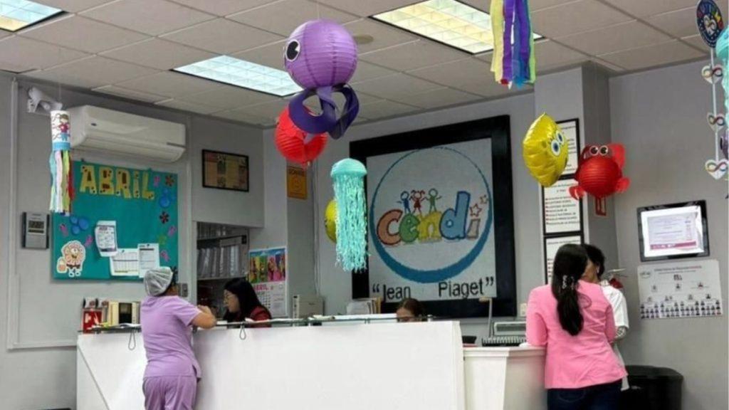 Reception Desk at a Pediatric Clinic with Colorful Hanging Lanterns and a Large Circular Logo on the Wall Behind. - Glen Facturero