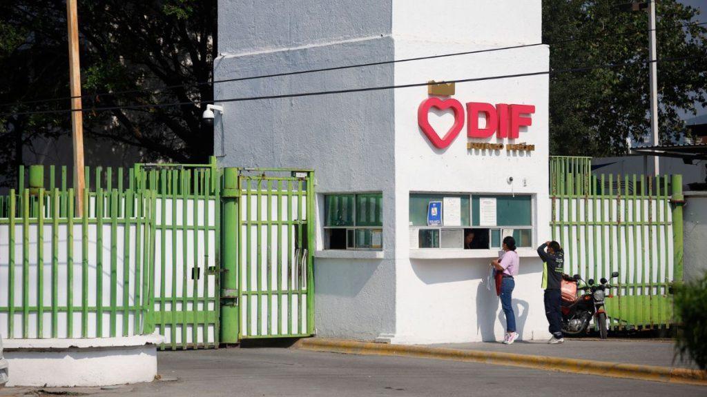 White Building with Red Dif Sign and Heart Logo; Two People Stand at the Service Window Beside a Green Gate. - Glen Facturero