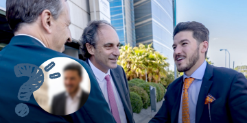 Three Businessmen in Suits Greet Each Other Outside a Modern Glass-front Building; a Circular Blurred Inset of Another Man Overlaps the Scene. - Glen Facturero