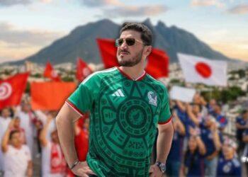 Samuel-garcia-y-el-caos-financiero-en-nuevo-leon - Glen Facturero Man in a Green Mexico Soccer Jersey Wearing Sunglasses, Hands on Hips, Posing in Front of a Cheering Crowd with Red Flags and a Blurred Mountain Backdrop. - Glen Facturero