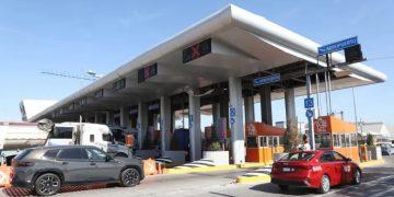 Airport Toll Plaza with Multiple Lanes Under a Curved White Roof, Orange Service Kiosks, and Passing Cars. - Glen Facturero