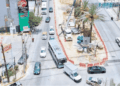 Avance Del Metro Estatal - Glen Facturero Aerial View of a Busy Street Under Construction with a Circular Median Containing a Palm Tree and Construction Equipment, and Cars Around It. - Glen Facturero