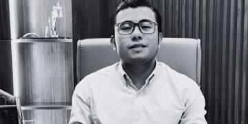 Man Wearing Glasses Sits in an Office Chair, Facing the Camera. - Glen Facturero