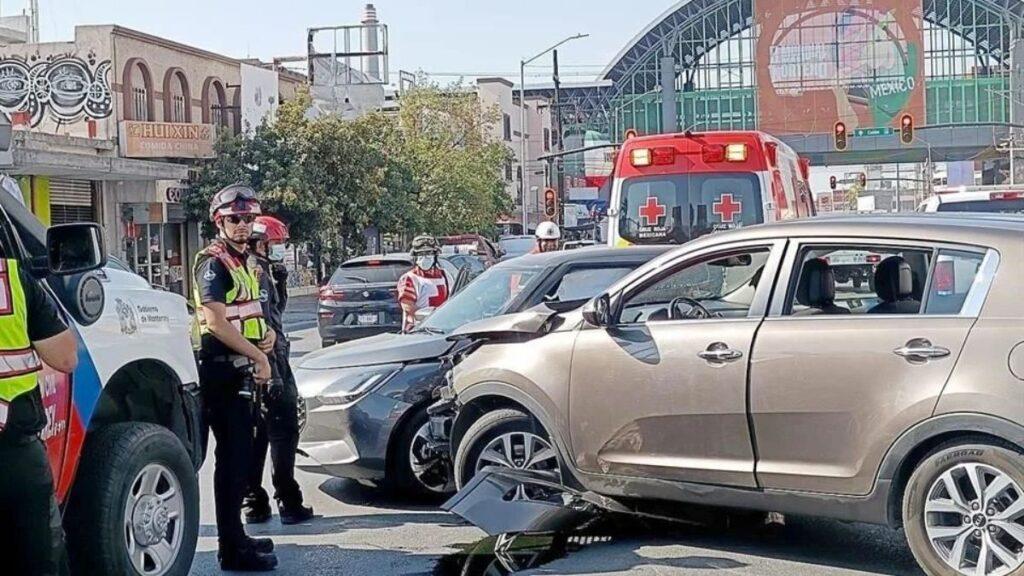 Muevoleon-choques-nuevo-leon - Glen Facturero Traffic Collision with Multiple Cars and Emergency Responders at an Intersection; a Beige Suv Rear-rammed by Another Vehicle, with Responders in Reflective Vests and a Medevac Ambulance in the Background - Glen Facturero
